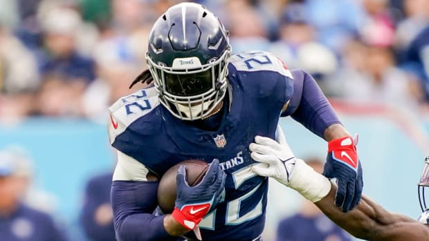 Titans running back Derrick Henry goes past a defender with the ball.
